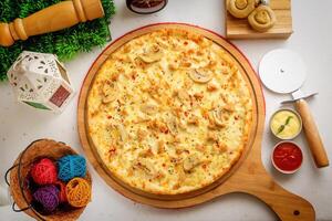 Pollo Alfredo pizza with tomato sauce and mayo isolated on wooden board top view of italian food on wooden background photo