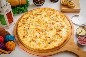 Pollo Alfredo pizza with tomato sauce and mayo isolated on wooden board top view of italian food on wooden background photo