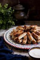 Assorted mosakhan fried roll served in a dish isolated n wooden table side view photo