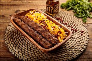 Chelo Kebab Kobideh served in a wooden cutting board isolated on wooden background side view photo