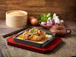 Hot Plate Tofu with Preserved Cai Xin and Minced Pork served in a dish isolated on mat side view on grey background photo