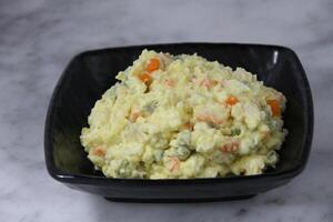 Olivieh Salad served in a dish isolated on grey background side view photo