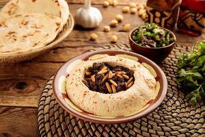 HUMUS BIL LAHAM served in a dish isolated on wooden table background side view of appetizer photo