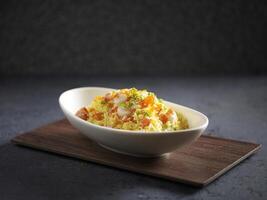 Supreme Seafood Fried Rice served in a dish isolated on cutting board side view on dark background photo