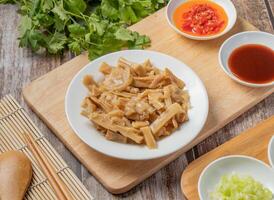 Braised dried pork bamboo shoot with chilli sauce, noodles, spoon and chopsticks served in dish isolated on napkin top view of hong kong food photo