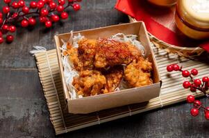 Japanese Tangyang Fried Chicken in a dish with chopsticks isolated on mat side view on wooden table taiwan food photo