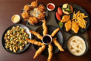 Garlic Mushroom, Vegetables Pakora, Prawn Tempura, Grilled Fish, swatted vegetables, chilli and soy sauce, mayo dip served in dish isolated on background top view of bangladesh and indian food photo