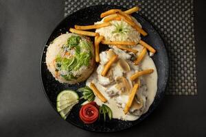 mushroom chicken piccata, fried rice, fries and salad served in dish isolated on background top view of bangladesh and indian food photo