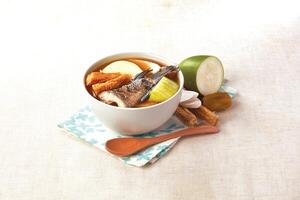 Codonopsis, Huaizaojie, Gourd and Mountain Spotted Fish Soup served in a bowl isolated on napkin side view of hong kong food photo