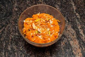 gajar halwa o Zanahoria halva con nueces, almendra, pistacho, khoya, Leche y petróleo servido en plato aislado en antecedentes parte superior ver de Bangladesh y indio comida foto