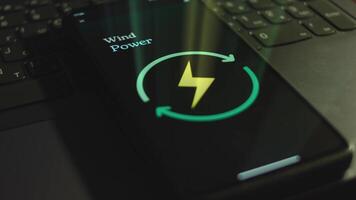 Wind Energy inscription on smartphone screen. Graphic presentation with Energy, Electricity, Power symbol on black background. Light rays. Power and Energy concept video