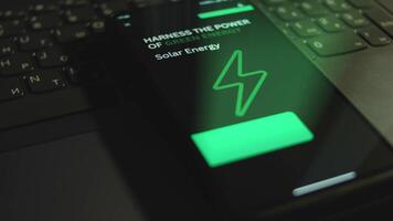 Harness the power of green energy. Solar Energy. Inscription on smartphone screen. Graphic presentation with flickering Energy symbol on black background. Power and energy concept. Light rays video