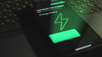 Harness the power of green energy. Energy Policy. Inscription on smartphone screen. Graphic presentation with green neon color Energy symbol on black background. Power and energy concept. Light rays video