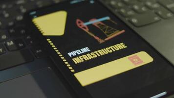 Pipeline Infrastructure inscription on smartphone screen. Graphic presentation with offshore oil drilling platform symbol. Oil and gas concept video