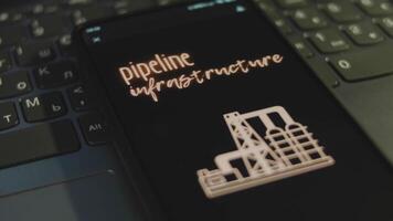 Pipeline Infrastructure inscription on smartphone screen with black background. Graphic presentation with oil refinery plant symbol. Oil and gas concept video
