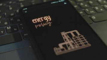 Energy Policy inscription on smartphone screen with black background. Graphic presentation with natural gas production plant symbol. Oil and gas concept video