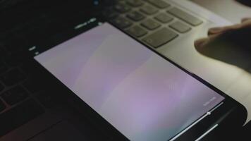 Abstract background of purple waves on smartphone screen. Rays of light come from screen. Male hand flapping with fingers cheerfully video