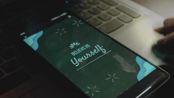 tro i själv inskrift på smartphone skärm. strålar av ljus komma från skärm. manlig hand fladdrande med fingrar glatt video