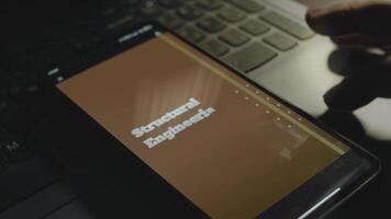 strukturell teknik inskrift brun bakgrund på smartphone skärm. konstruktion begrepp. manlig hand fladdrande med fingrar glatt video