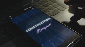 construção gestão inscrição em Smartphone tela. construção conceito. masculino mão agitando com dedos alegremente video