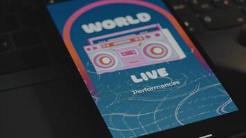 World live performances inscription. Graphic presentation with cassette recorder drawing on smartphone screen. Male hands flapping fingers cheerfully. VHS effect video