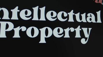 Intellectual Property inscription on black background, graphic presentation. Legal concept video