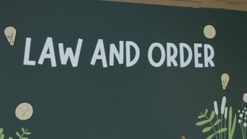 Law and Order inscription on chalkboard background. Graphic presentation of drawn teacher and student standing at chalkboard. Legal concept video