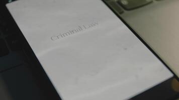 criminel loi une inscription sur téléphone intelligent filtrer. graphique présentation avec paisible vue de vagues de clair l'eau et mer sable. légal concept video