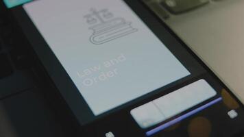 Law and Order inscription on smartphone screen. Graphic presentation on light blue background with Scales as symbol of Judicial System. Legal concept video