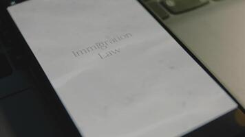 Immigration Law inscription on smartphone screen. Graphic presentation with clear water waves on sunny day. Legal concept video