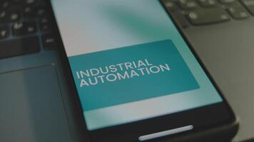 Industrial Automation inscription on smartphone screen. Graphic presentation with abstract background. Manufacturing concept video