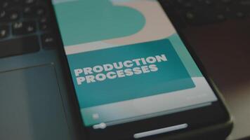 Production Processes inscription on smartphone screen. Graphic presentation with abstract background. Manufacturing concept video