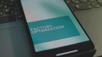 Factory Optimization inscription on smartphone screen. Graphic presentation with illustrated moving clouds on background. Manufacturing concept video