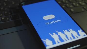 Land Warfare inscription on smartphone screen with blue background. Graphic presentation with silhouette of a group of soldiers with guns. Military concept video