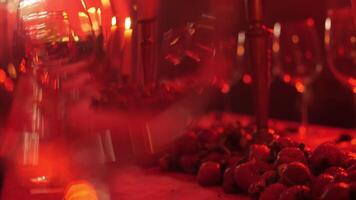 décorations pour une romantique soir des lunettes et bougies sur le table dans rouge lumière video