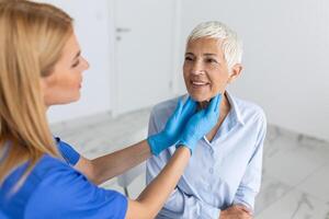 medicamento, cuidado de la salud y médico examen concepto - médico o enfermero comprobación del paciente anginas a hospital. endocrinólogo examinando garganta de mayor mujer en clínica foto