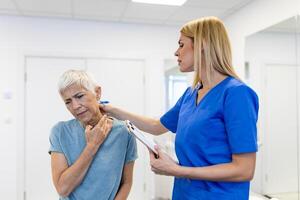 Licensed chiropractor or manual therapist doing neck stretch massage to relaxed female patient in clinic office. Young woman with whiplash or rheumatological problem getting professional doctor's help photo