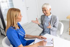 cuidado de la salud y médico concepto - médico con paciente en hospital. médico trabajando en el oficina y escuchando a el paciente, ella es explicando su síntomas, salud cuidado y asistencia concepto foto