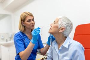 Doctor in a protective suit taking a throat and nasal swab from a patient to test for possible coronavirus infection photo