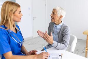 cuidado de la salud y médico concepto - médico con paciente en hospital. médico trabajando en el oficina y escuchando a el paciente, ella es explicando su síntomas, salud cuidado y asistencia concepto foto