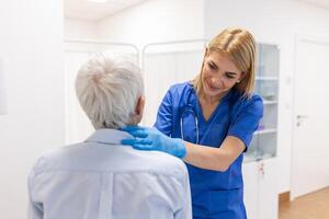 Endocrinologist examining throat of senior woman in clinic. Women with thyroid gland test . Endocrinology, hormones and treatment. Inflammation of the sore throat photo