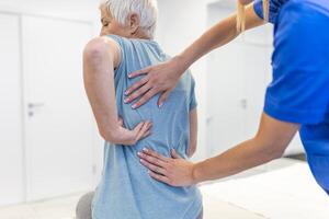 Senior woman having chiropractic back adjustment. Osteopathy, Alternative medicine, pain relief concept. Physiotherapy, injury rehabilitation photo