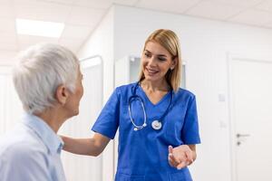 Senior woman, doctor and elderly patient with good news, tablet and results for health, advice and report. Happy medic, clipboard with smile, tech or support in hospital photo