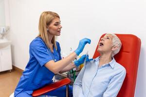 Doctor in a protective suit taking a throat and nasal swab from a patient to test for possible coronavirus infection photo