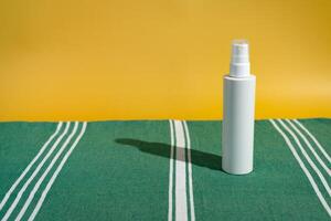 Blank sunscreen bottle on beach towel photo