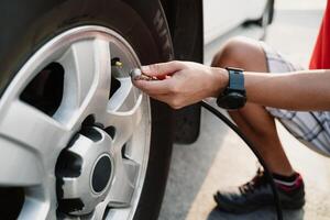 A man is inflating a tire with a tire inflator photo