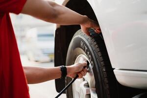 A man is inflating a tire with a tire inflator photo