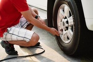 A man is inflating a tire with a tire inflator photo