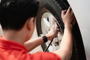 A man is inflating a tire with a tire inflator photo