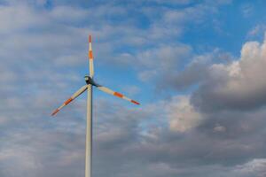 Wind turbine on the background of the blue sky. Clean renewable energy. Electric power production. photo